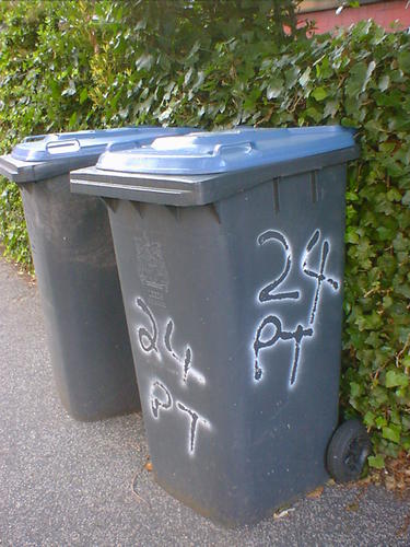 24 PT written on the side of a wheelie bin.
