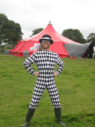 Andrew wears a black and white, diamond pattern, skin-tight, all-in-one suit.