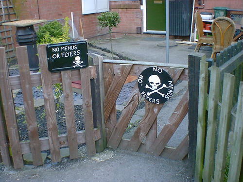 Two skull and crossbone warning signs: no menus or flyers!