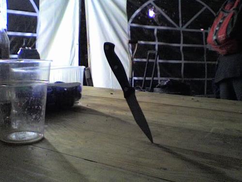 A knife stuck point first in a table