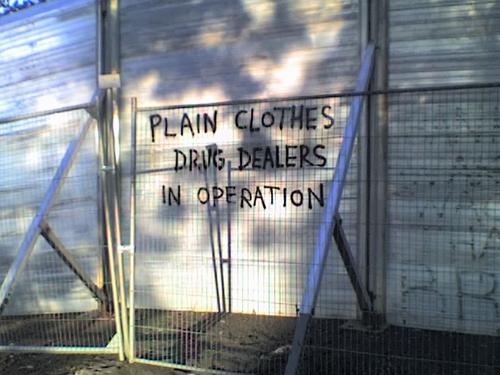 Graffiti reads: plain clothes drug dealers in operation