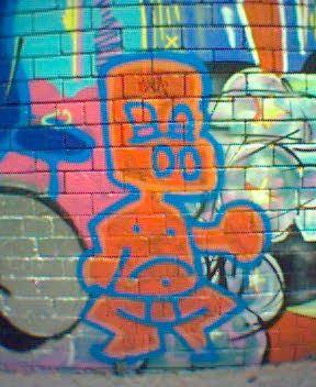 Graffiti art - a red-orange boy, outlined in blue, with big nostrils.