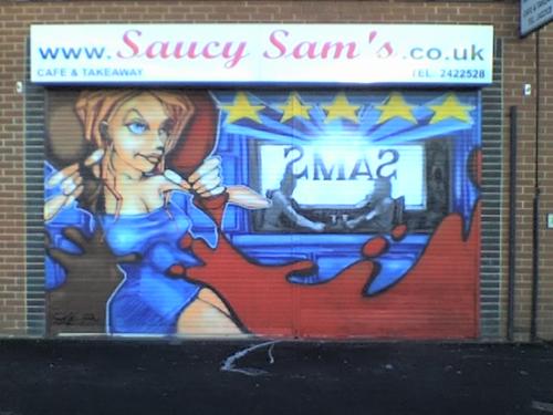 Graffiti-style artwork on the steel roll-shutters of a sandwich shop. 