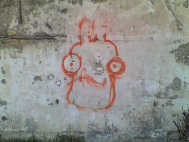 graffiti on decaying wall, a googley-eyed face resembling Admiral Akbar