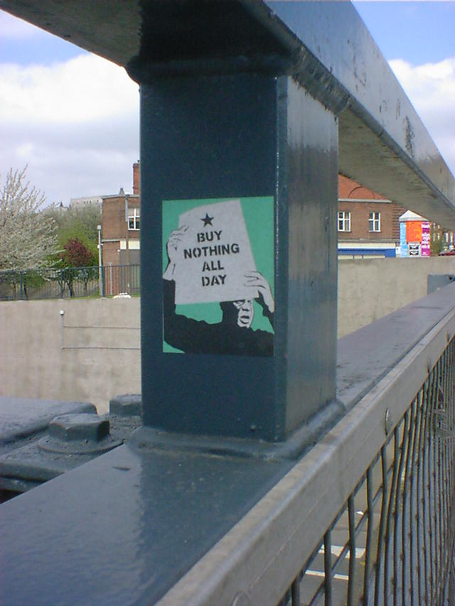 A sticker on some railings, reads buy nothing all day.