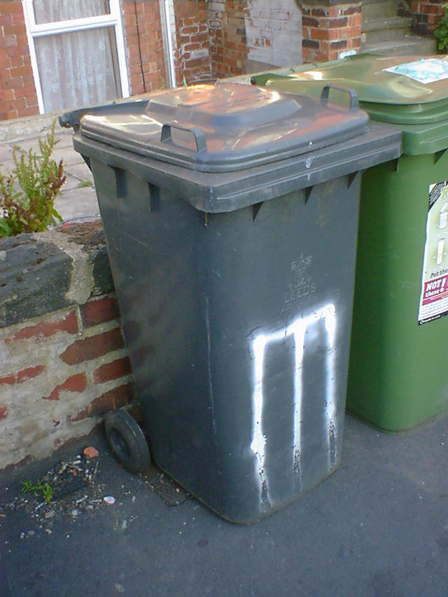 Cricket stumps spray-painted on a wheelie bin.