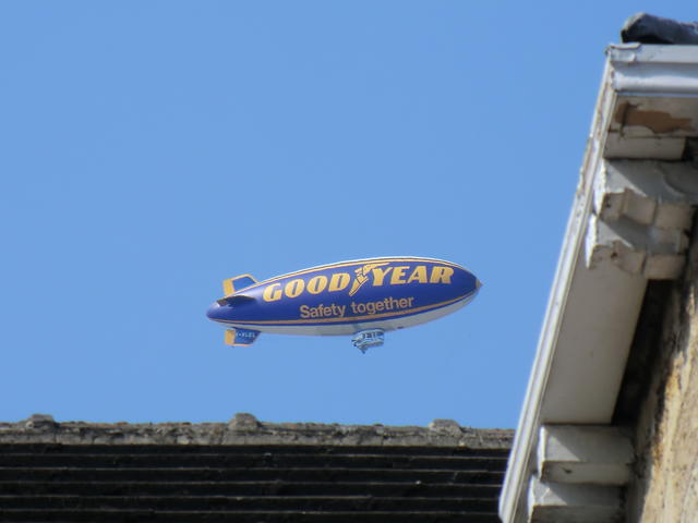 Photo of a Goodyear blimp above rooftop