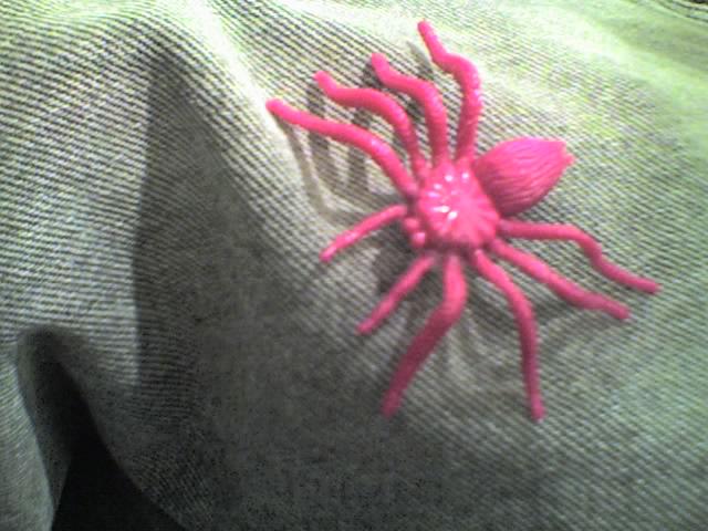 A bright pink plastic spider toy