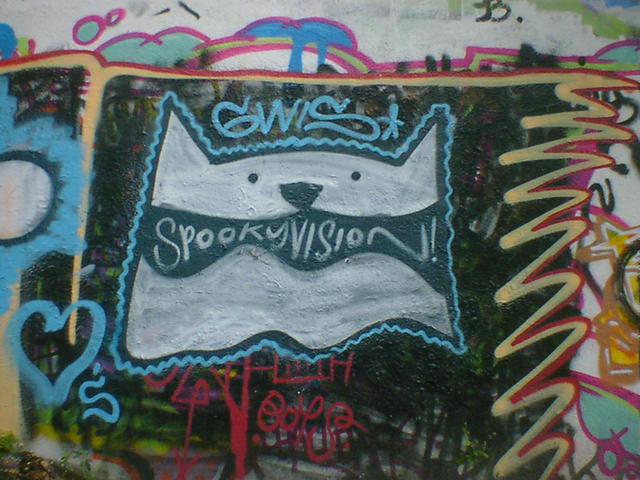 Graffiti of a dog, with spooky vision written inside the mouth.