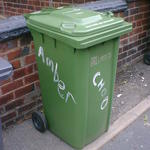 Green wheelie bin with Amber and Choo daubed on two sides with white paint. 