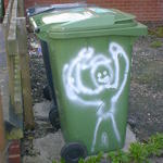 A grinning man painted on a wheelie bin, holding his arms high in victory.