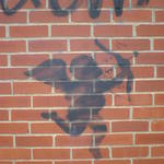 Silhouette of Cupid with bow, stencilled on a brick wall