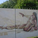 Graffiti artwork; a futuristic nude on some iron gates.