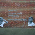 two wheatpaste posters of crying children, on a brick wall