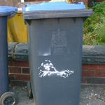 Stencil art on a wheelie bin. A monkey aiming a revolver, cop-show style.