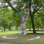 Tree trunk wrapped in plastic carrier bags.