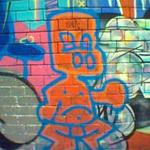 Graffiti art - a red-orange boy, outlined in blue, with big nostrils.