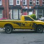 Yellow pickup truck with  Manga-style girl's eyes, painted on the side 