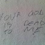 Graffiti reads: Your God Is Dead To Me